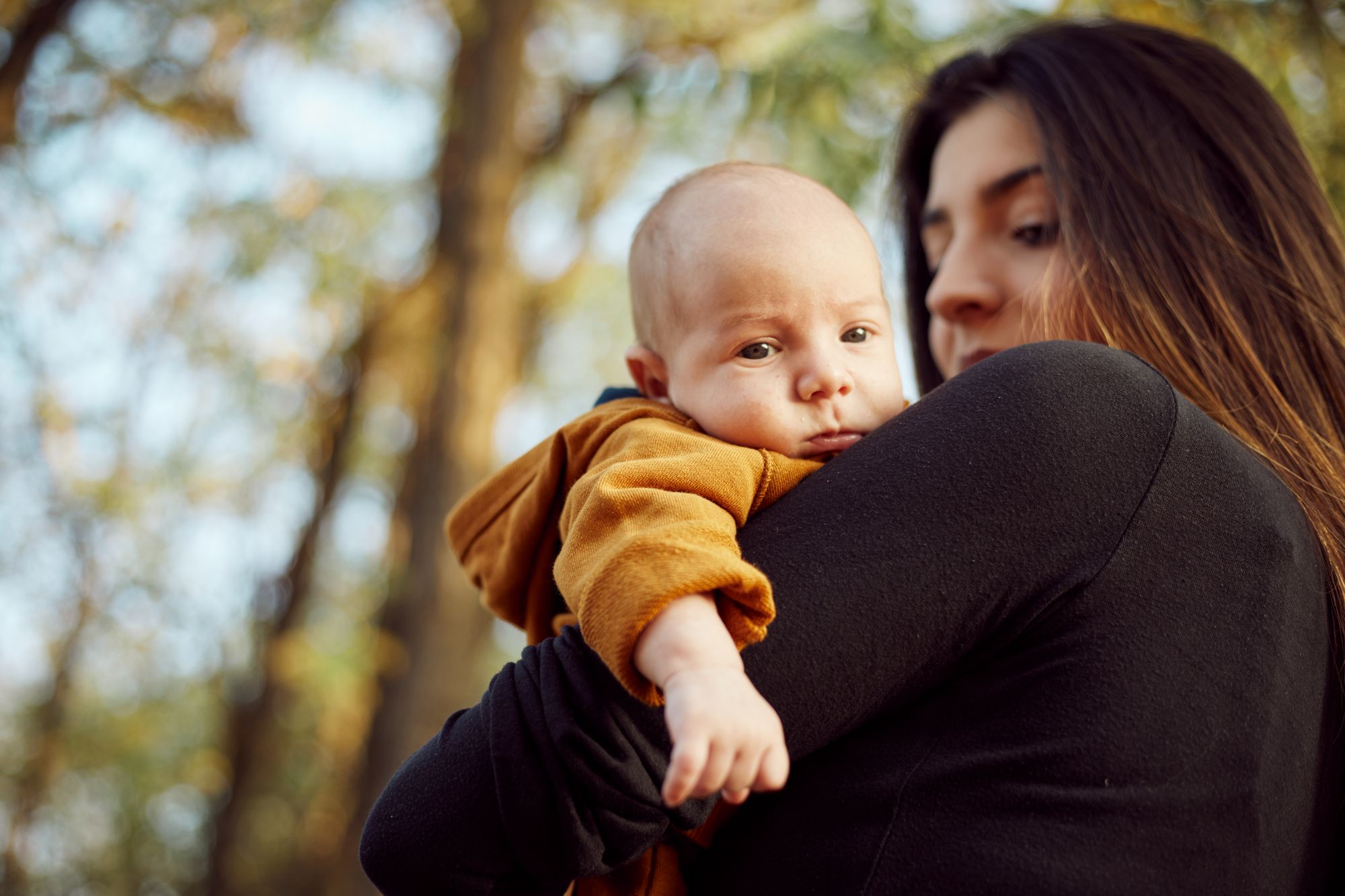 Madre tiene in braccio figlio che ha uno sguardo attento.